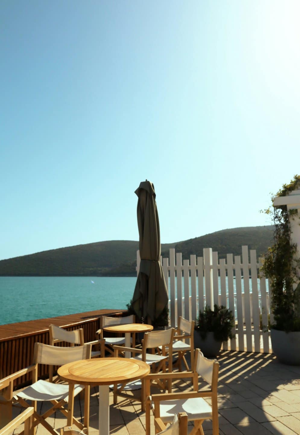 Terrazza di un caffè vuota con tavoli affacciati sul mare.