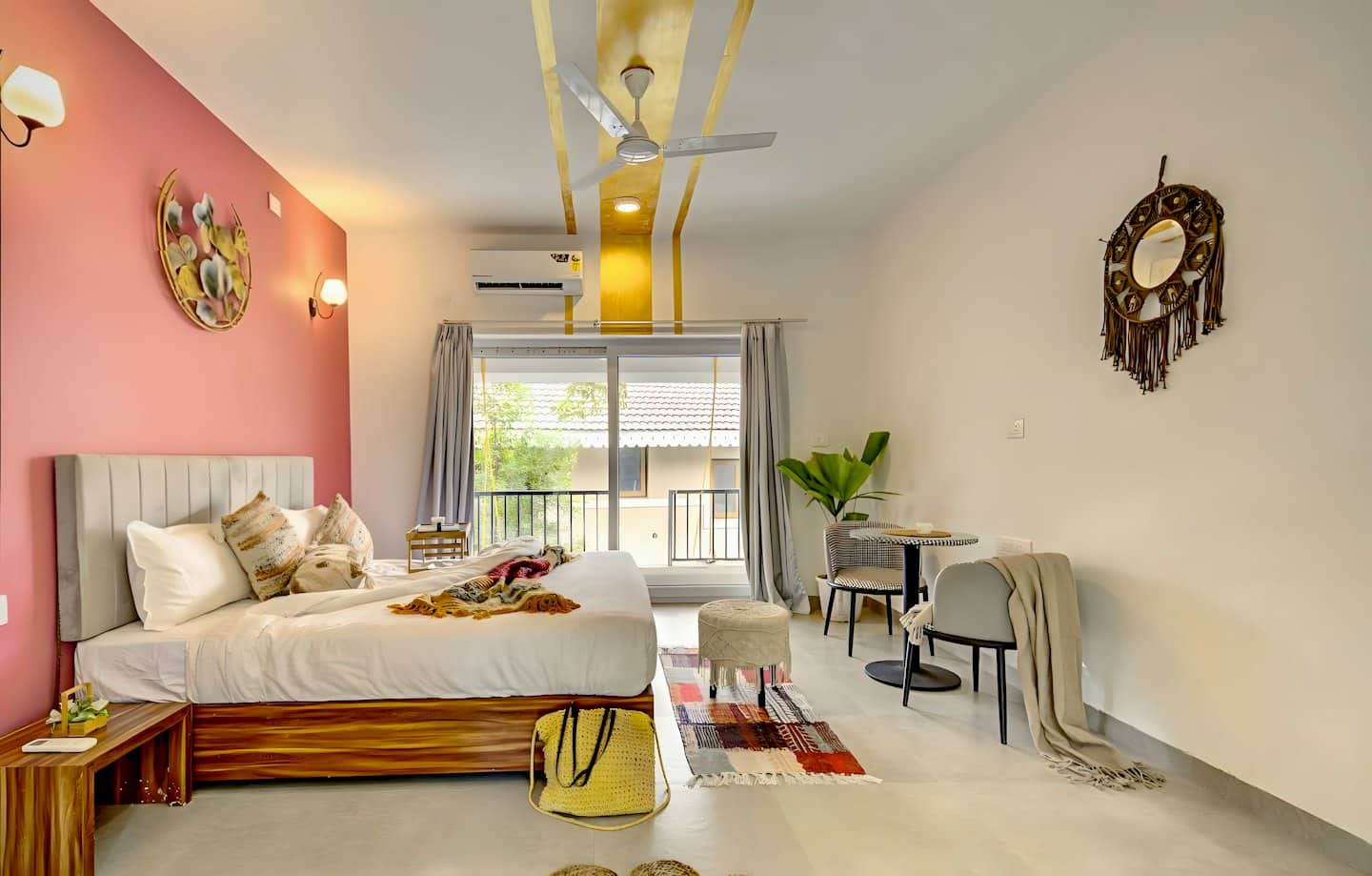 Moderna camera da letto di una suite d'albergo con parete d'accento rosa e balcone.
