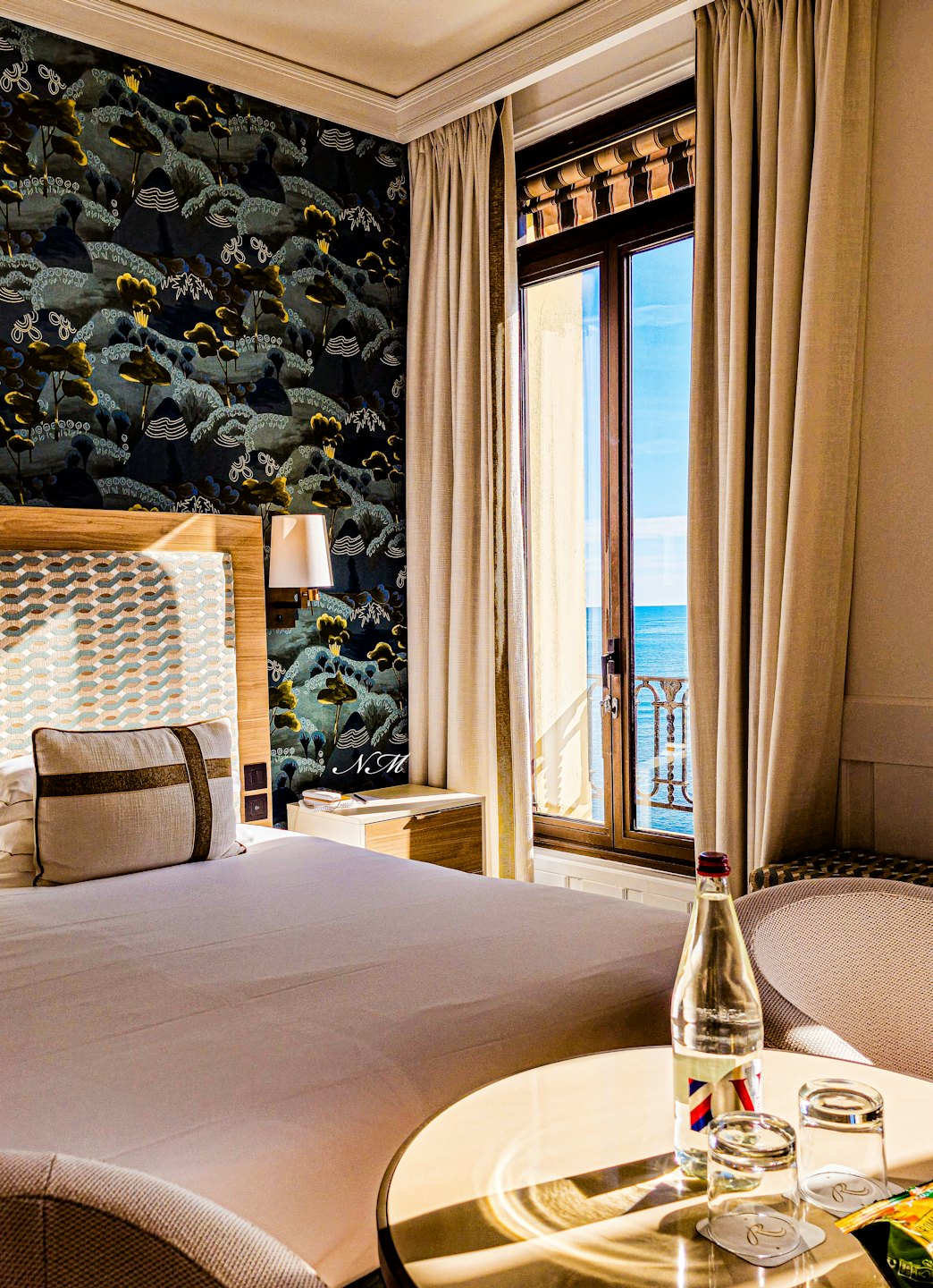 Camera d'albergo con letto e balcone vista mare.