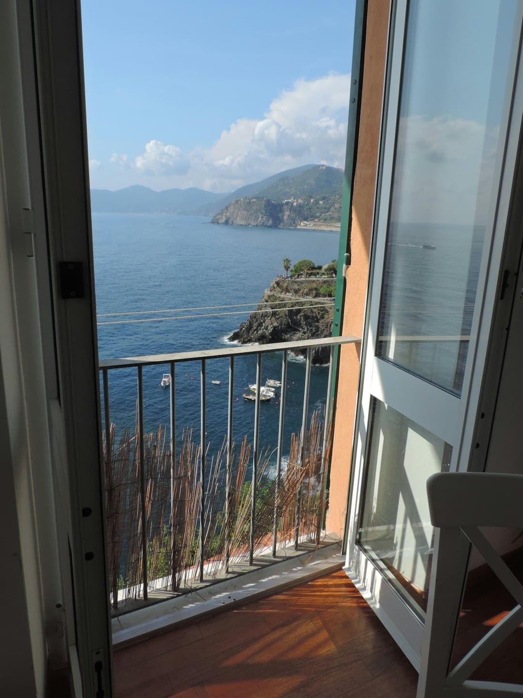 Vista costiera da un balcone con vista sulle barche in mare.